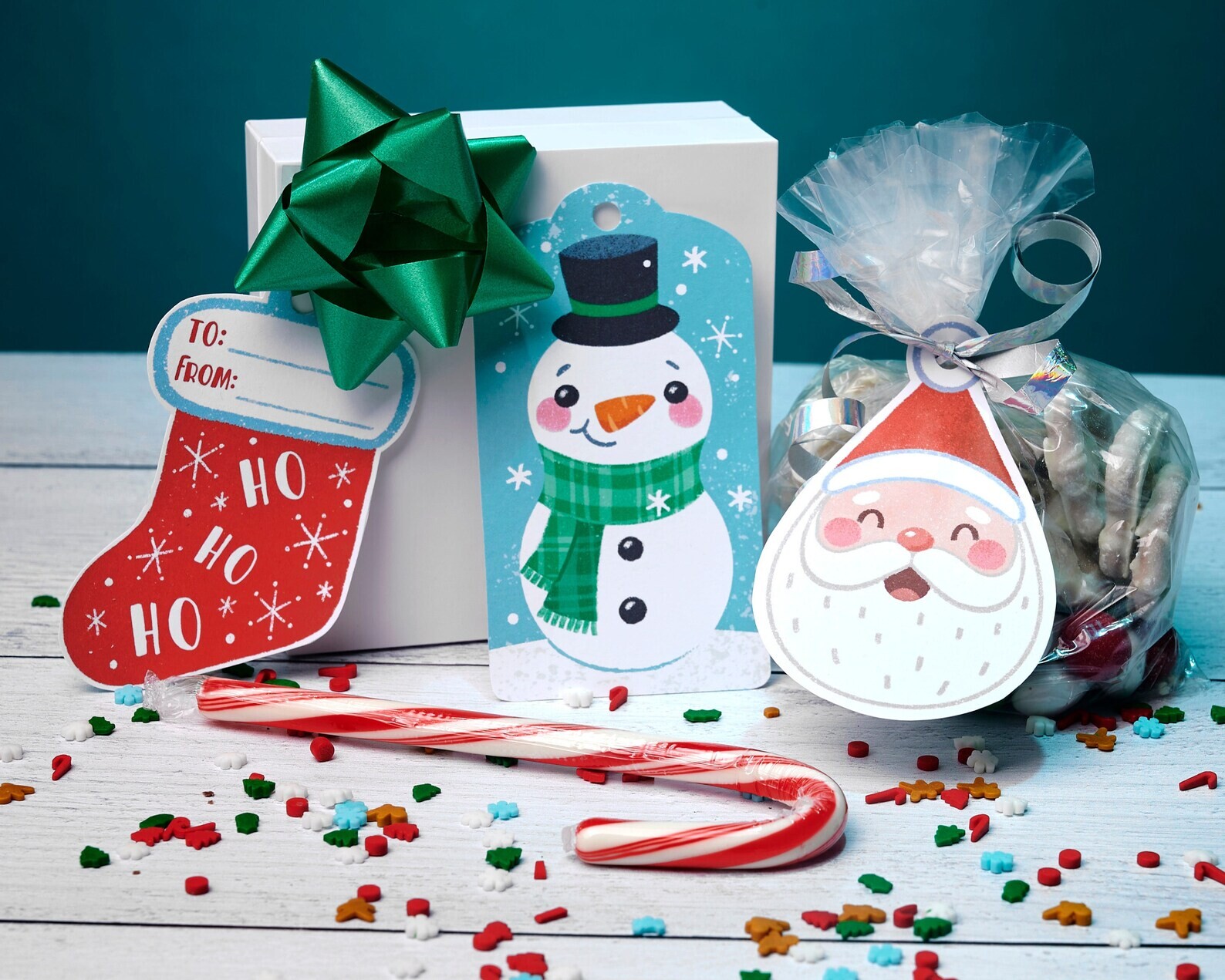 Photo of a wrapped gift box with snowman and Santa gift tags and a candy cane