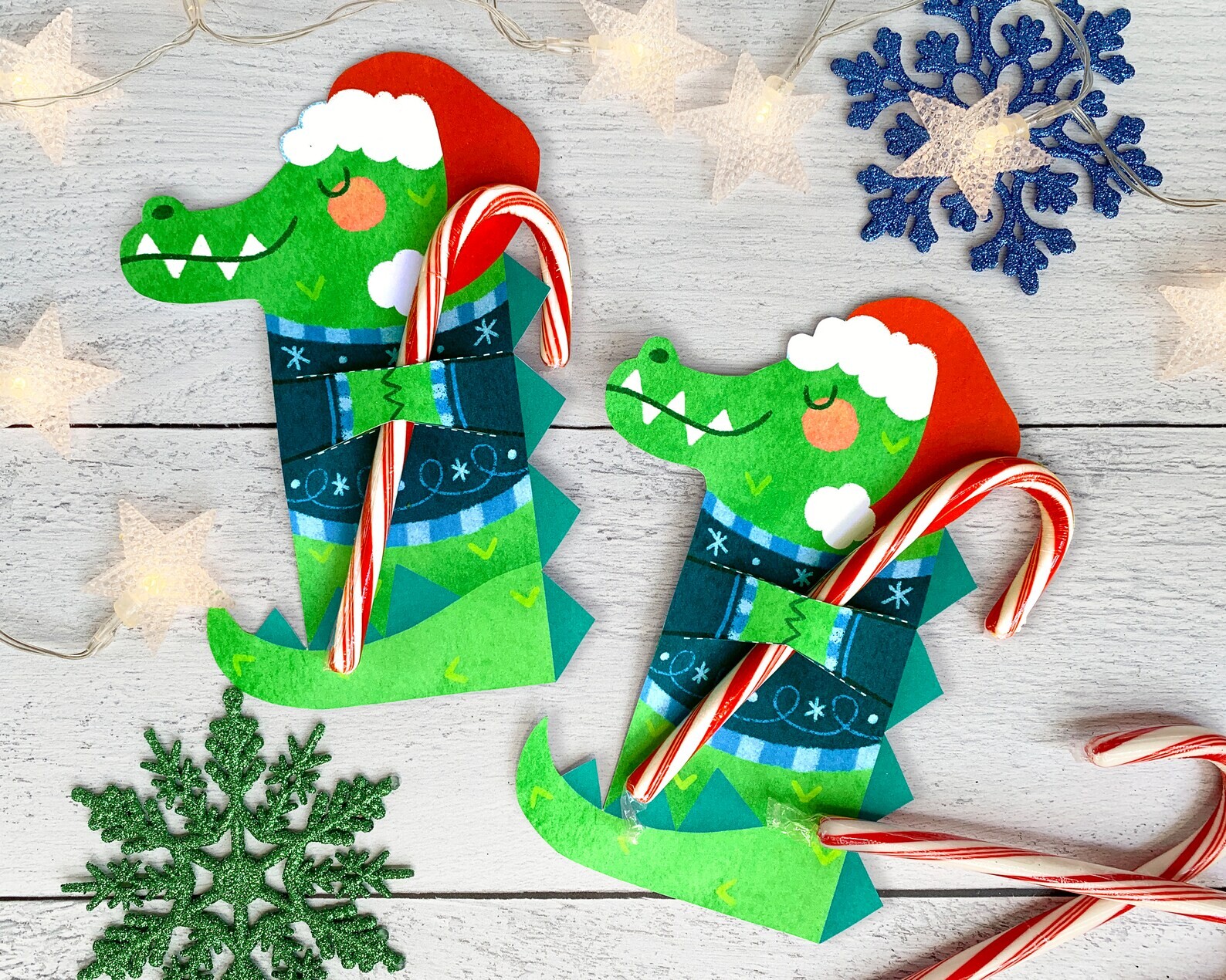 Photo of two paper alligator treat holders wrapped around candy canes